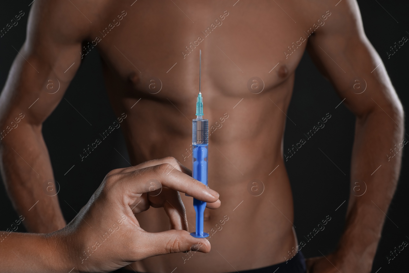 Photo of Woman holding syringe near athletic man on black background, closeup. Doping concept