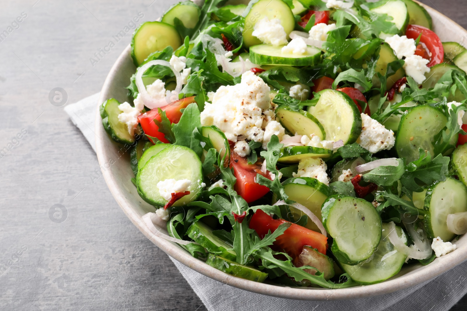 Photo of Plate of delicious cucumber salad on grey table, closeup