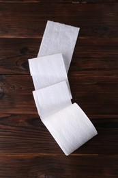 Photo of One soft toilet paper roll on wooden table, top view