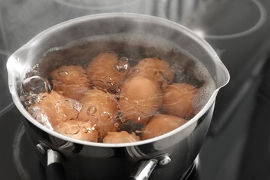 Cooking chicken eggs in pot on electric stove