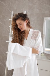Photo of Beautiful woman drying hair with towel in bathroom