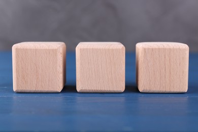 Photo of International Organization for Standardization. Cubes with abbreviation ISO on blue wooden table, closeup