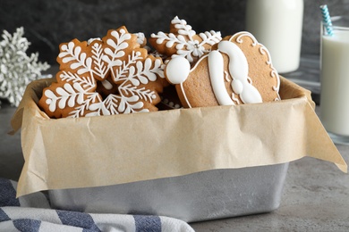 Decorated Christmas cookies in box on grey table
