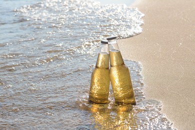 Photo of Bottles of cold beer in sea water on sunny day