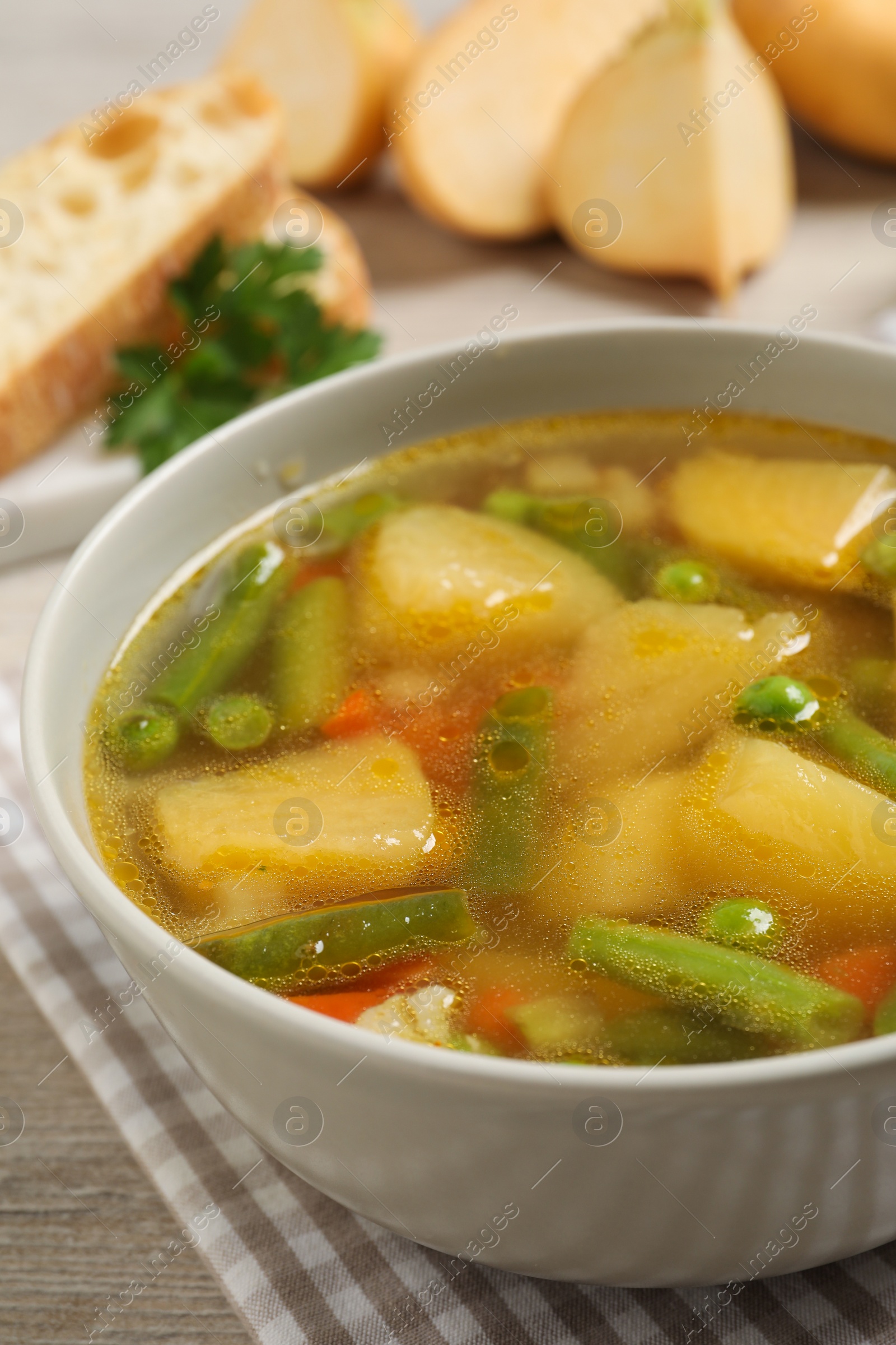 Photo of Bowl of delicious turnip soup on wooden table, closeup