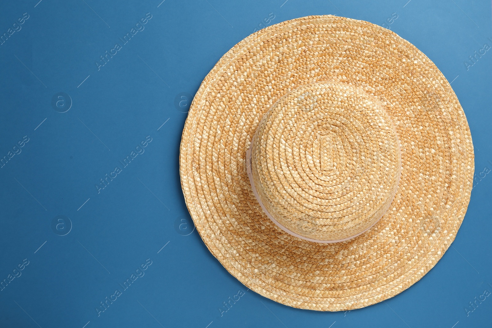 Photo of Stylish straw hat on blue background, top view. Space for text