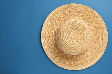 Photo of Stylish straw hat on blue background, top view. Space for text