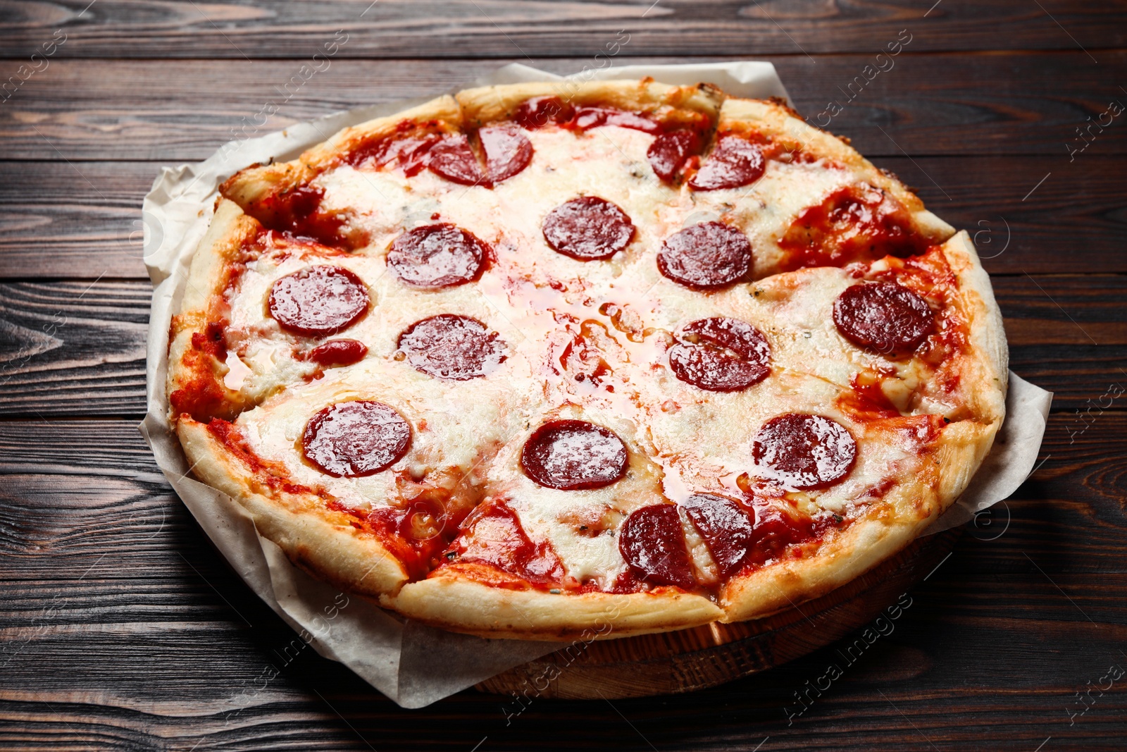 Photo of Hot delicious pepperoni pizza on wooden table