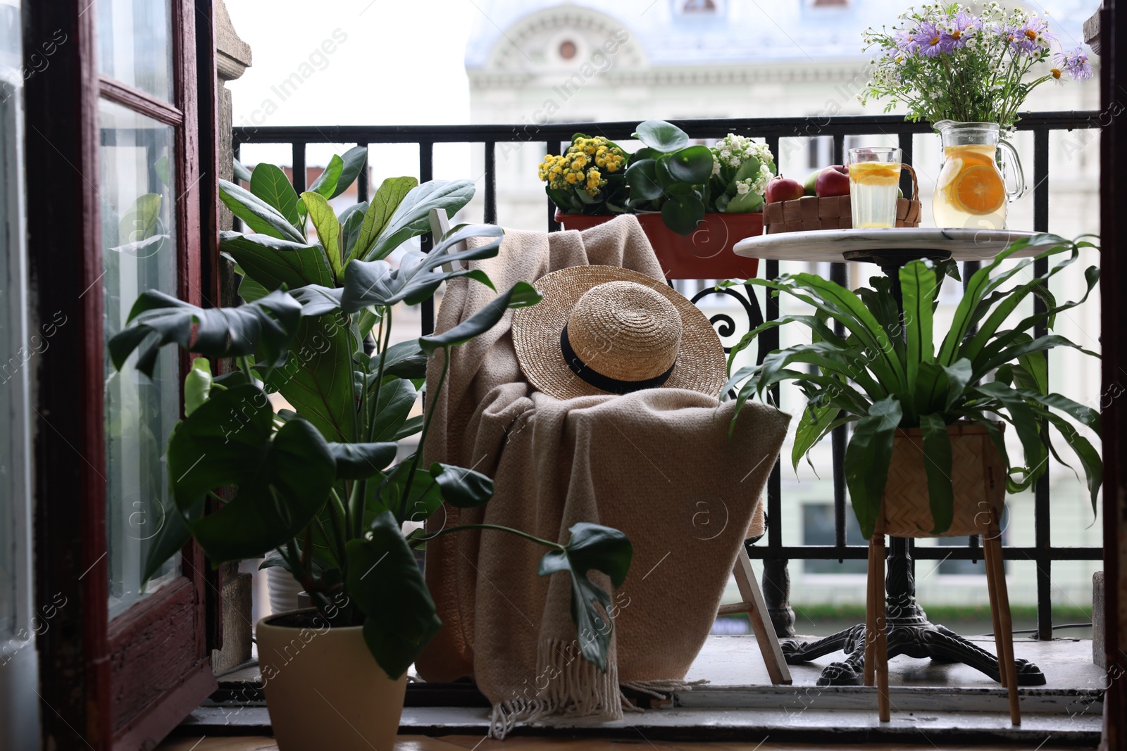 Photo of Relaxing atmosphere. Stylish furniture surrounded by beautiful houseplants on balcony