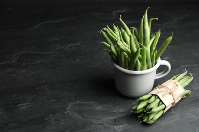 Photo of Delicious fresh green beans on black table, space for text