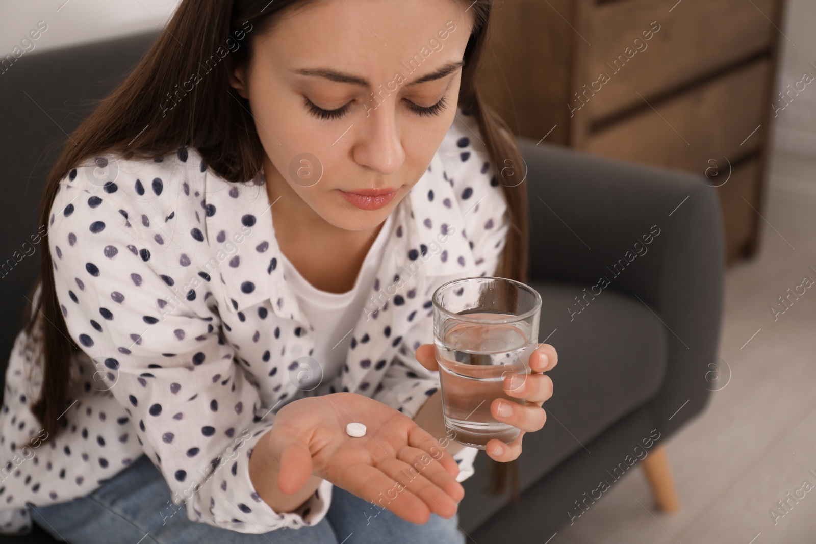 Photo of Young woman with abortion pill at home