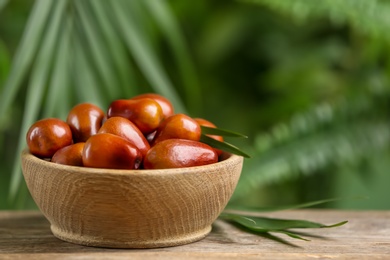 Photo of Fresh ripe oil palm fruits on wooden table, closeup. Space for text