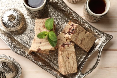 Photo of Tasty chocolate halva served on wooden table, flat lay