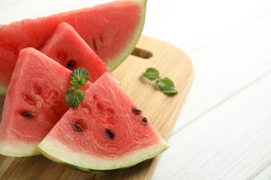 Photo of Tasty ripe cut watermelon on white wooden table, closeup