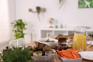 Photo of Healthy vegetarian food, jug of juice and glasses on table indoors