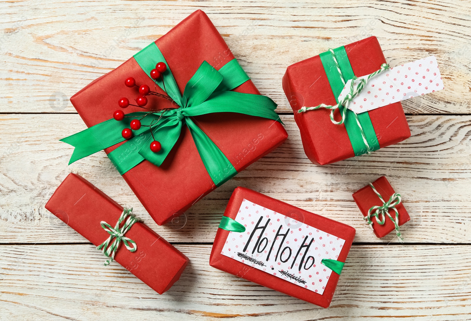 Photo of Christmas gift boxes on white wooden background, flat lay