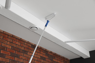 Photo of Painting ceiling with white dye indoors, low angle view