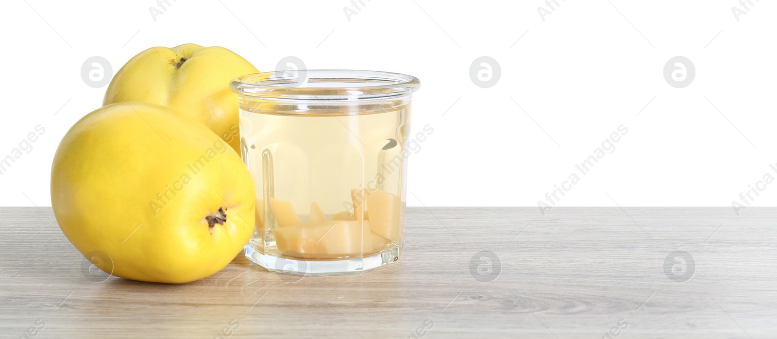 Photo of Delicious quince drink and fresh fruits on wooden table against white background