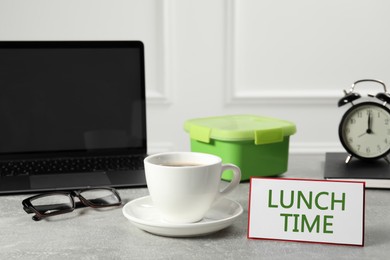 Image of Business lunch time. Workplace with cup of coffee, card and lunch box in office