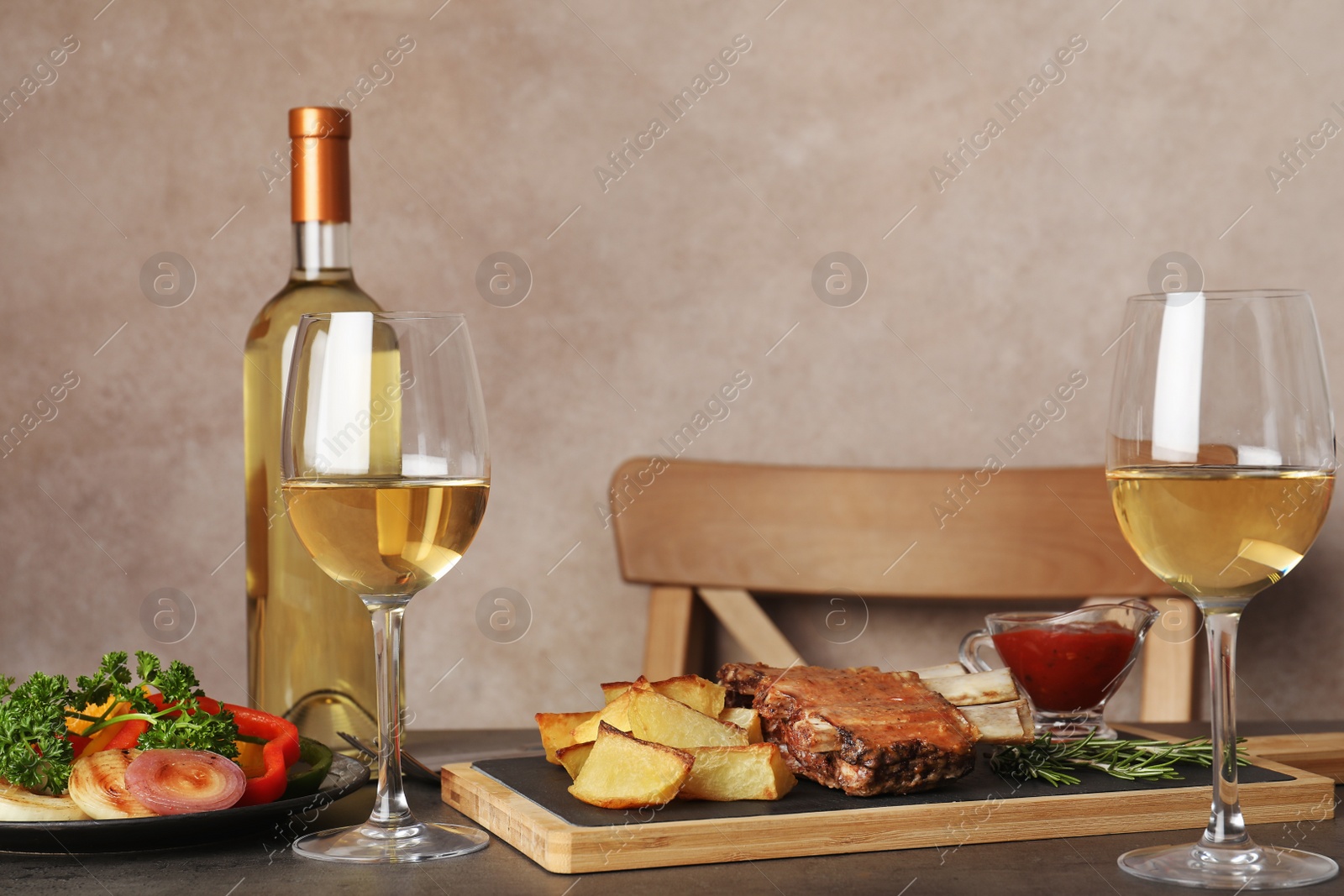 Photo of Fried ribs served with garnish, sauce and wine on table, space for text. Delicious meat