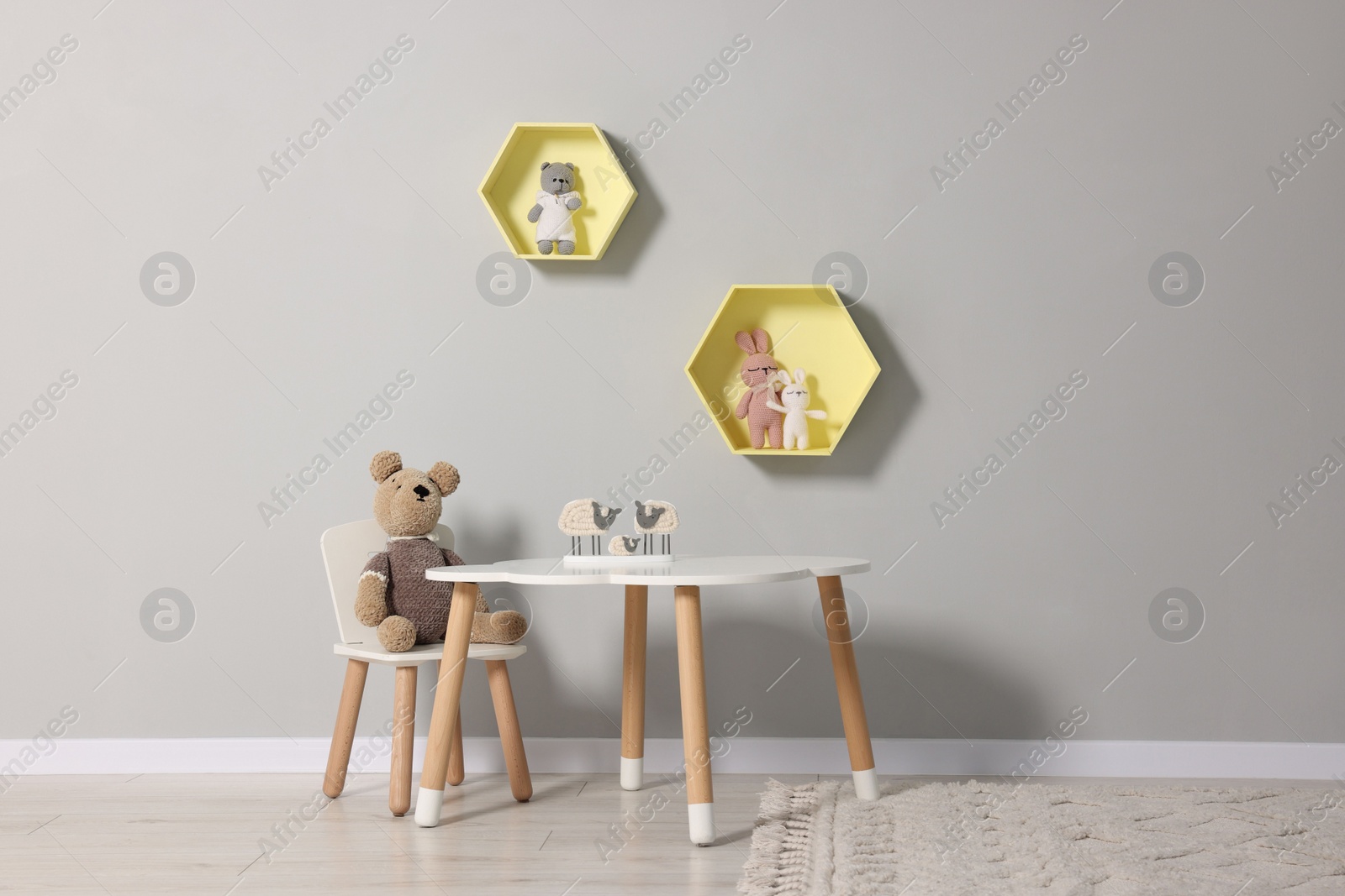 Photo of Beautiful children's room with grey wall, furniture and toys. Interior design