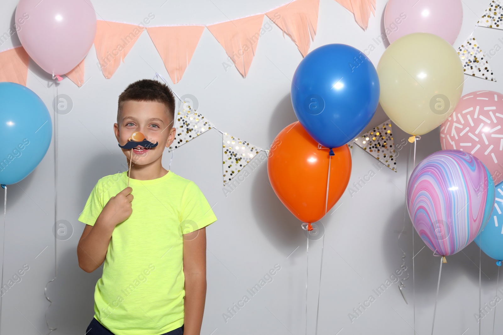 Photo of Happy boy near bright balloons at birthday party indoors