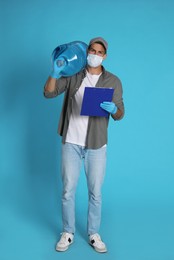 Courier in medical mask with bottle for water cooler and clipboard on light blue background. Delivery during coronavirus quarantine