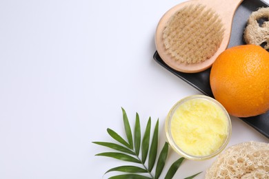 Photo of Orange, scrub and brush on white background, flat lay with space for text. Cellulite treatment