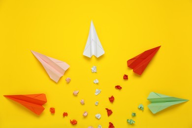 Photo of Flat lay composition with colorful paper planes on yellow background
