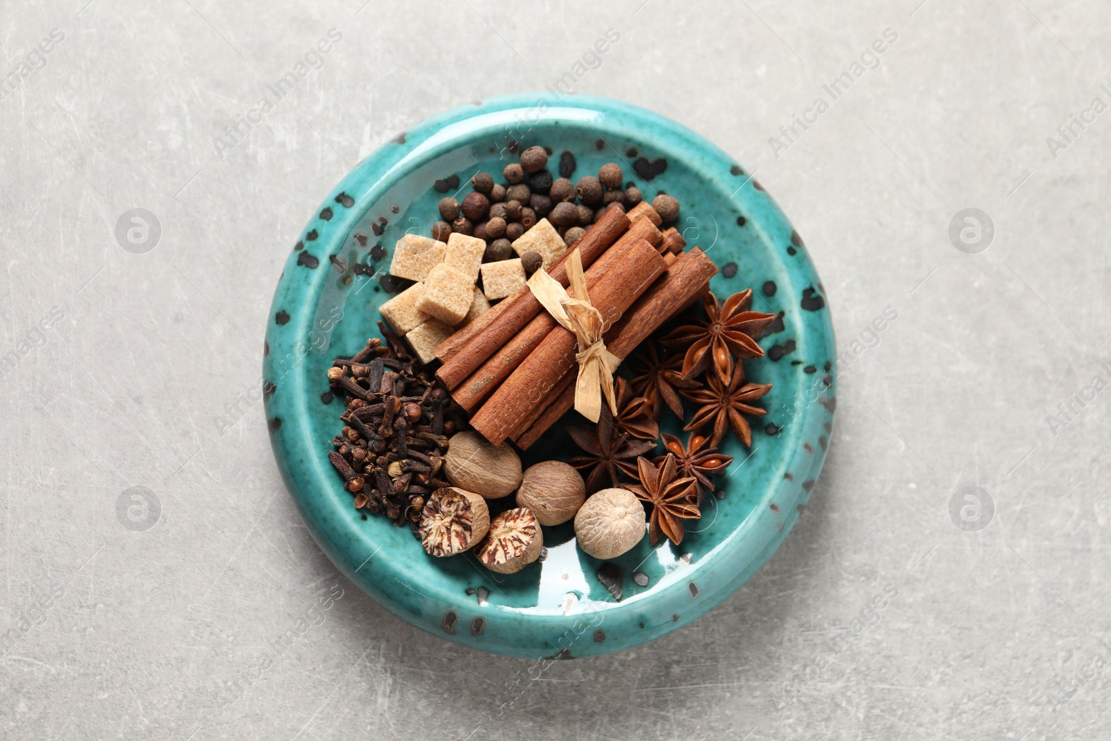 Photo of Different aromatic spices on light textured table, top view