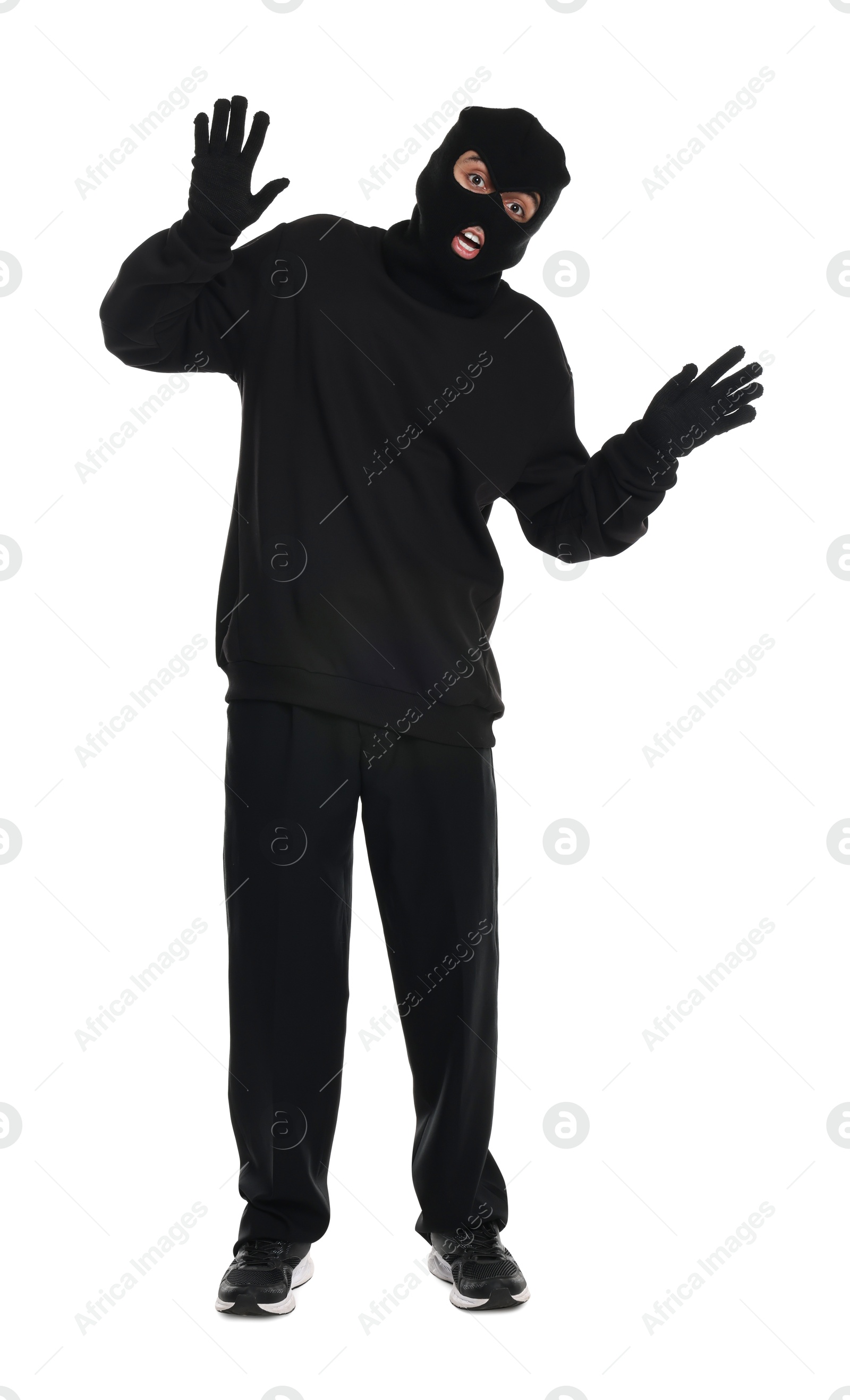 Photo of Emotional thief in balaclava raising hands on white background