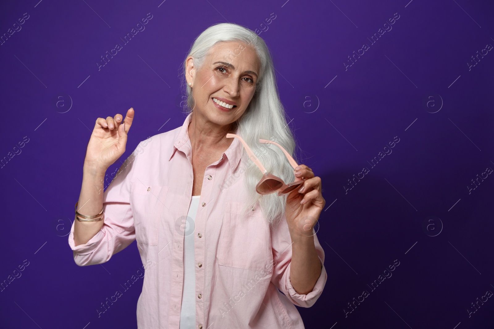 Photo of Portrait of beautiful mature woman on violet background, space for text