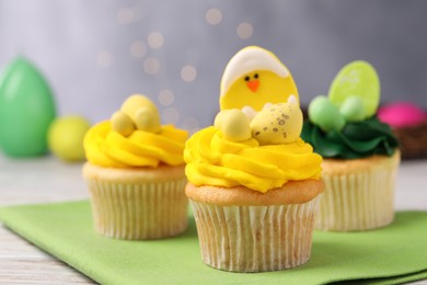 Photo of Tasty decorated Easter cupcakes on wooden table, closeup