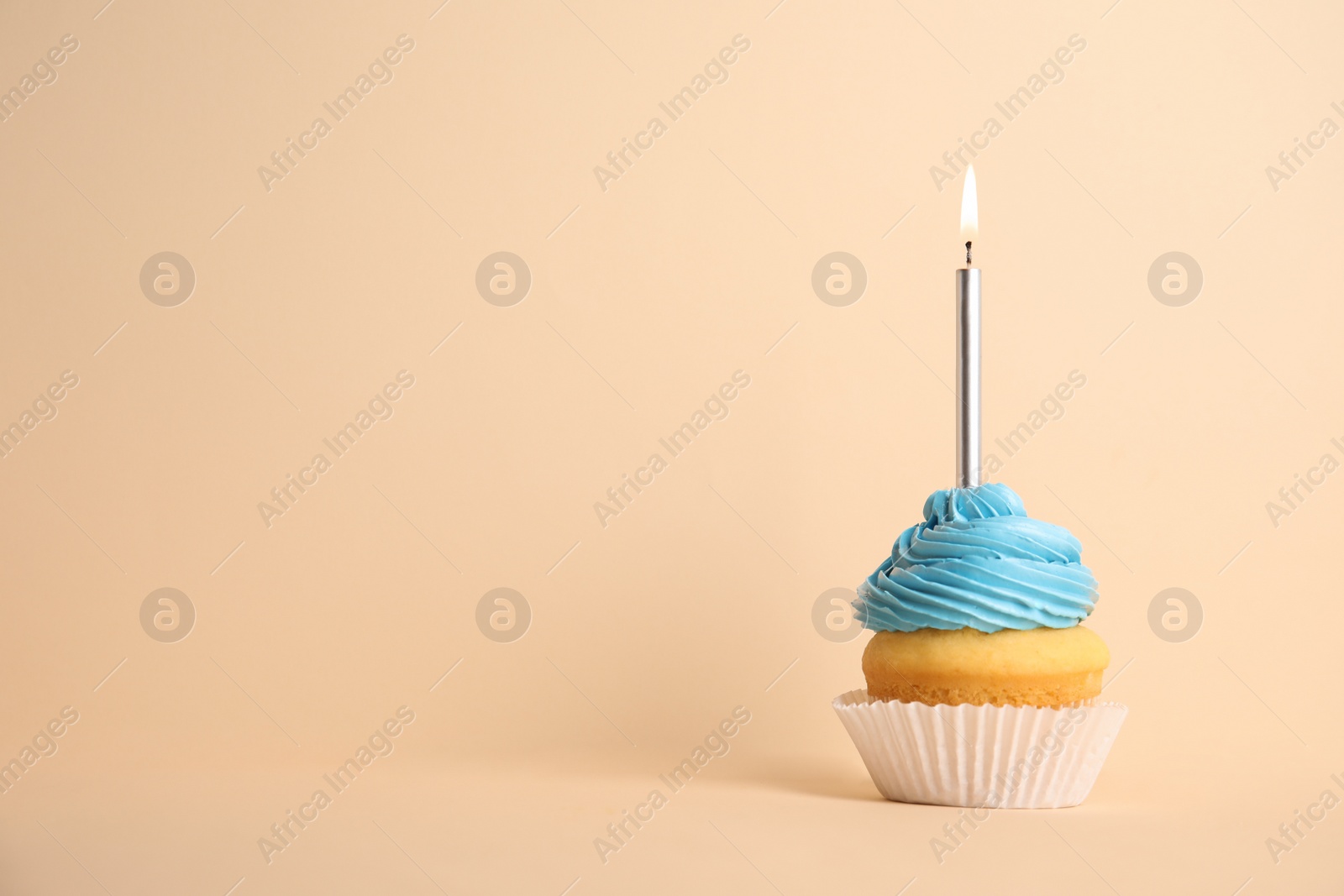 Photo of Birthday cupcake with candle on beige background, space for text