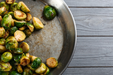 Delicious roasted brussels sprouts on grey wooden table, top view. Space for text