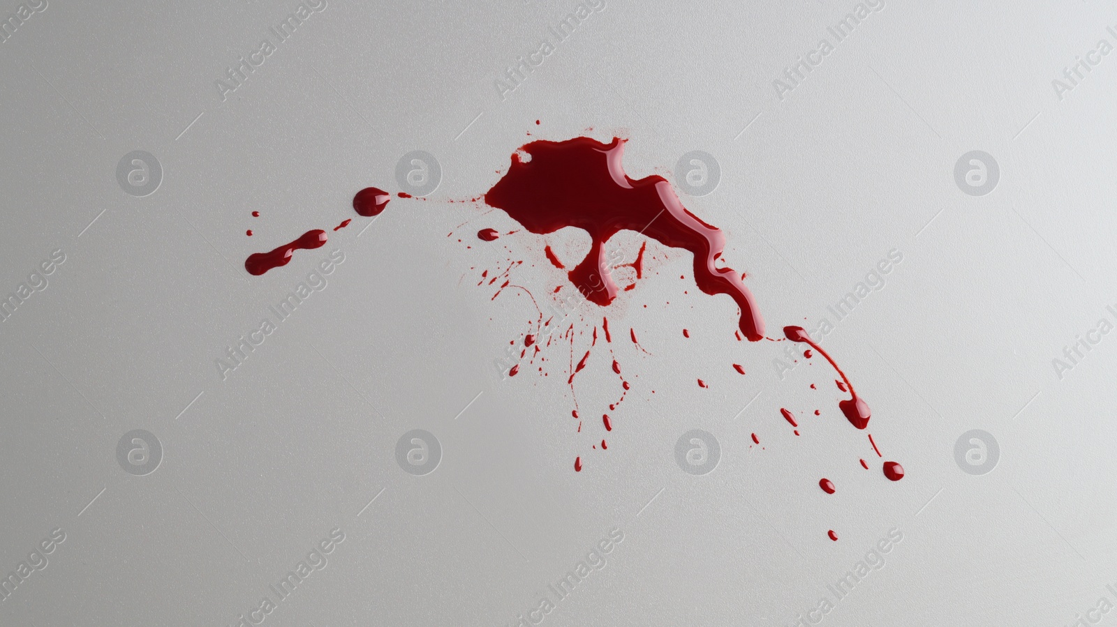 Photo of Stain and splashes of blood on light grey background, top view