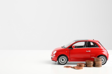 Toy car and money on white background, space for text. Vehicle insurance