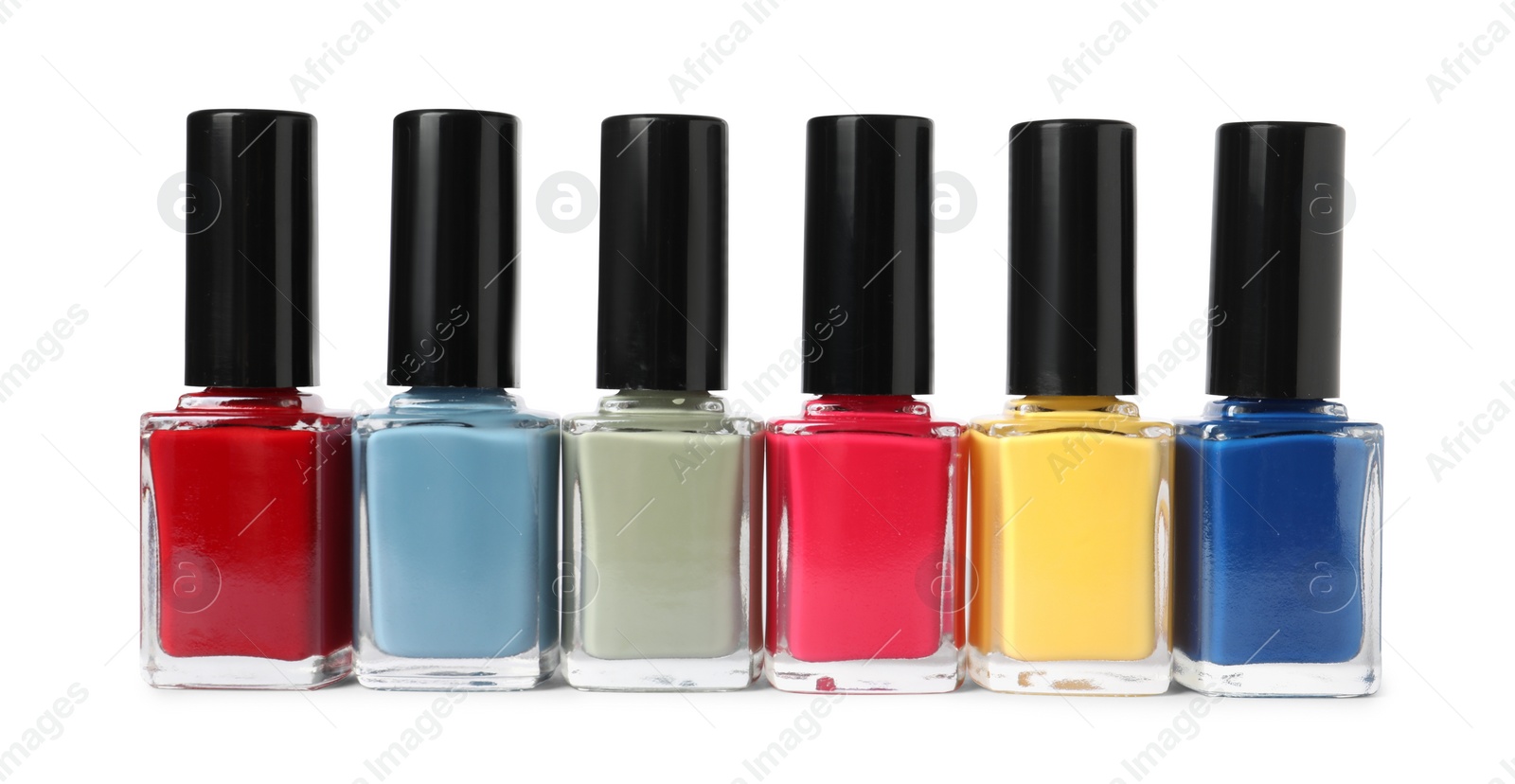 Photo of Bright nail polishes in bottles isolated on white