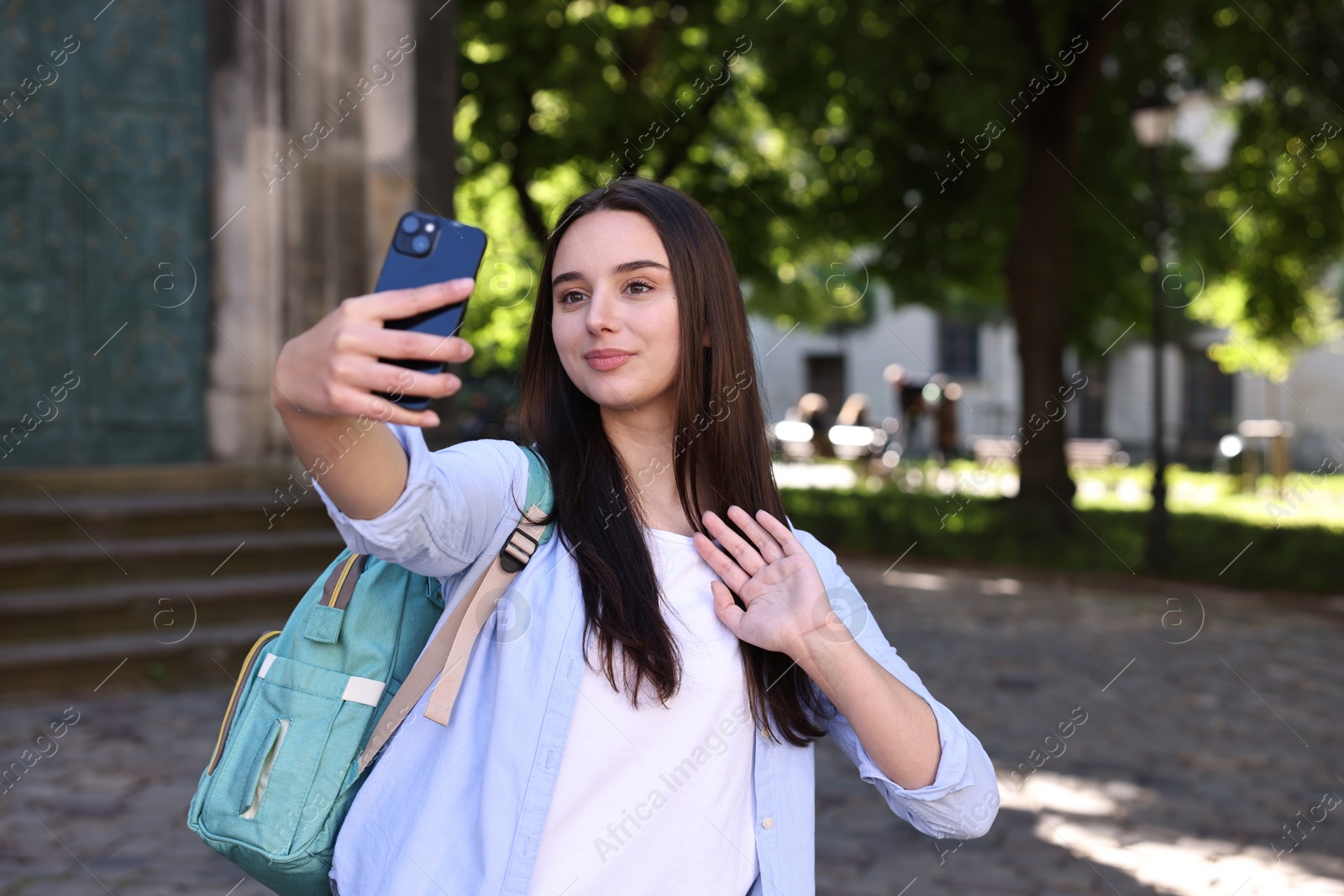 Photo of Beautiful travel blogger with smartphone streaming outdoors