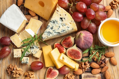 Set of different snacks with ripe figs served on wooden table, top view