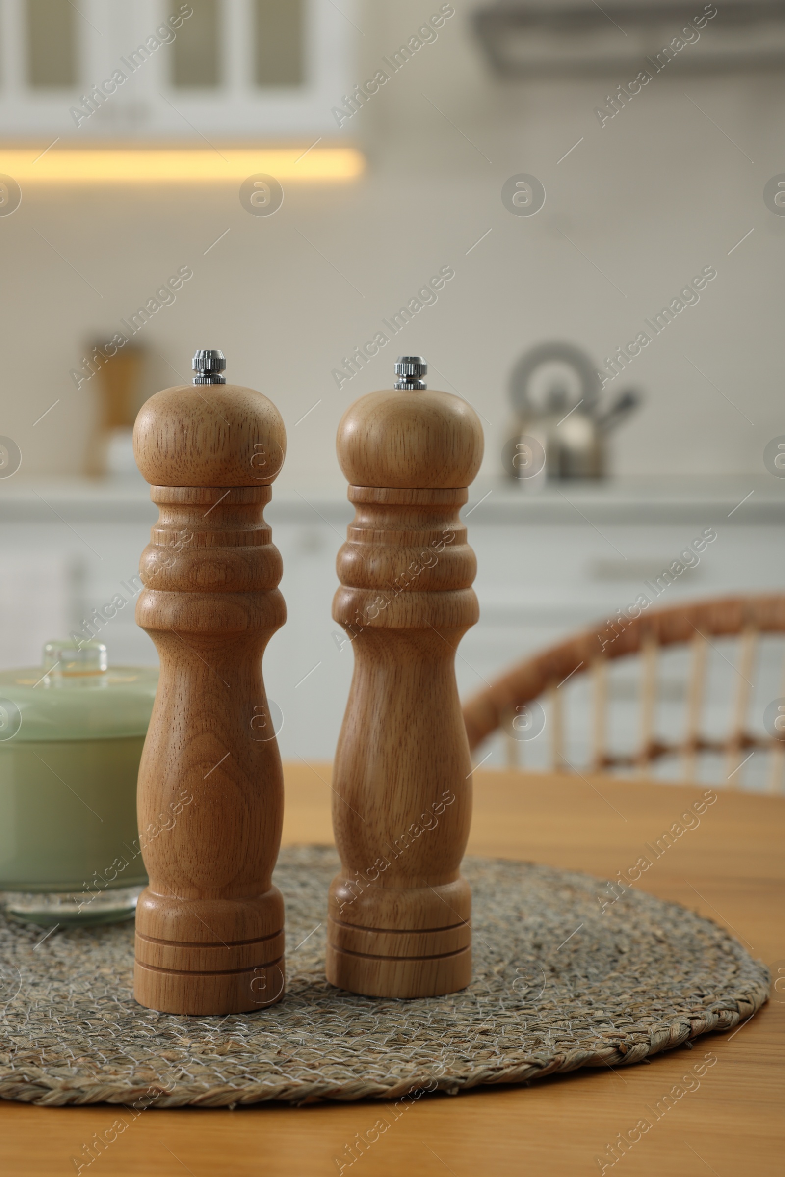 Photo of Wooden salt and pepper shakers on table in kitchen