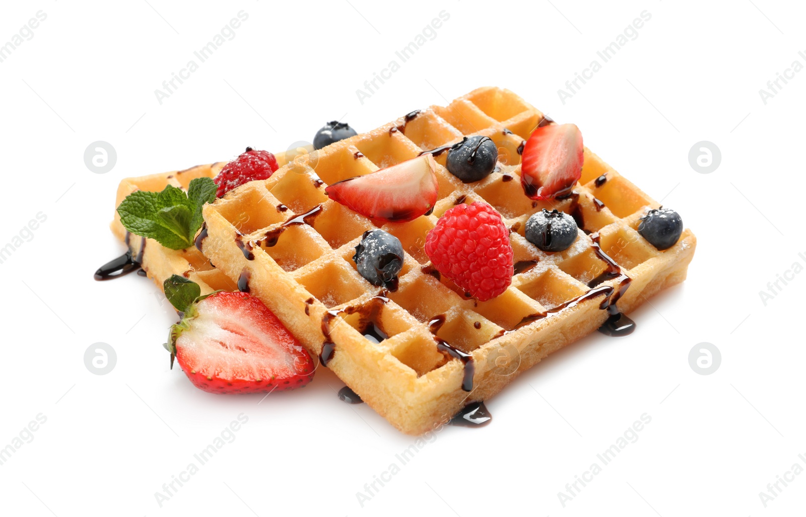 Photo of Yummy waffles with berries and chocolate syrup on white background