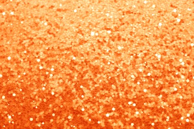 Image of Beautiful shiny orange glitter as background, closeup