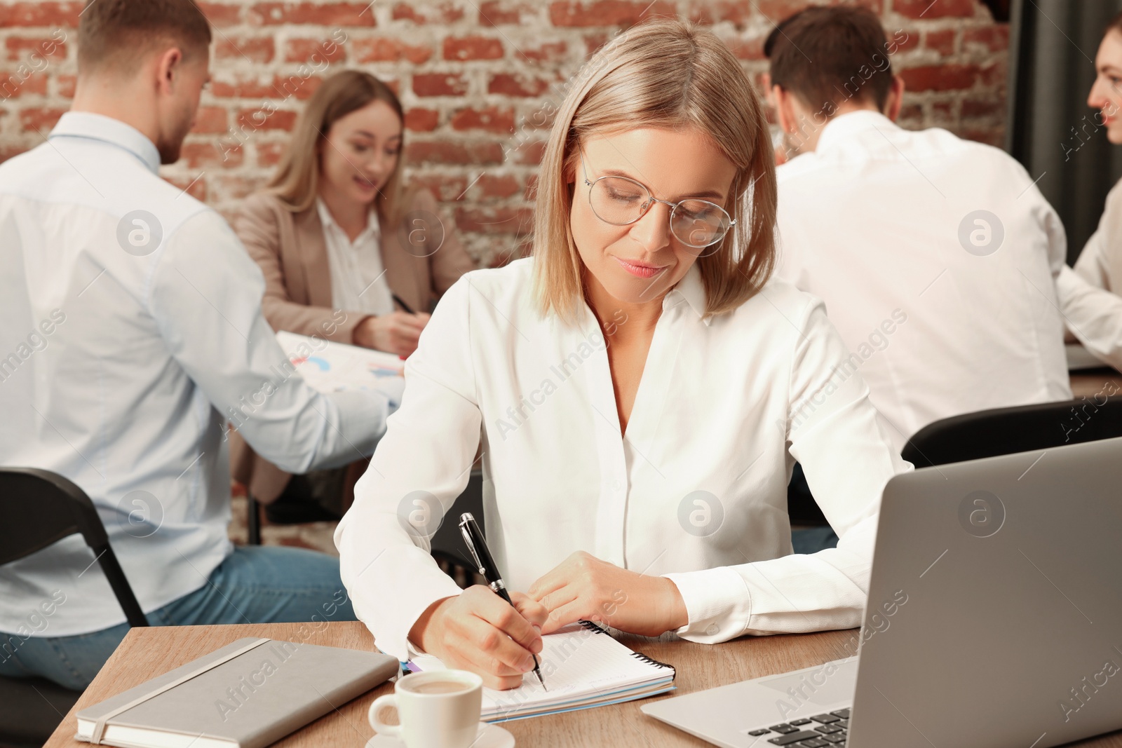 Photo of Businesswoman and her employees in office. Lady boss