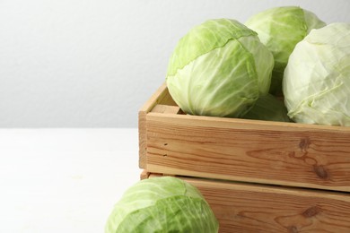 White cabbage in crate on table, closeup. Space for text