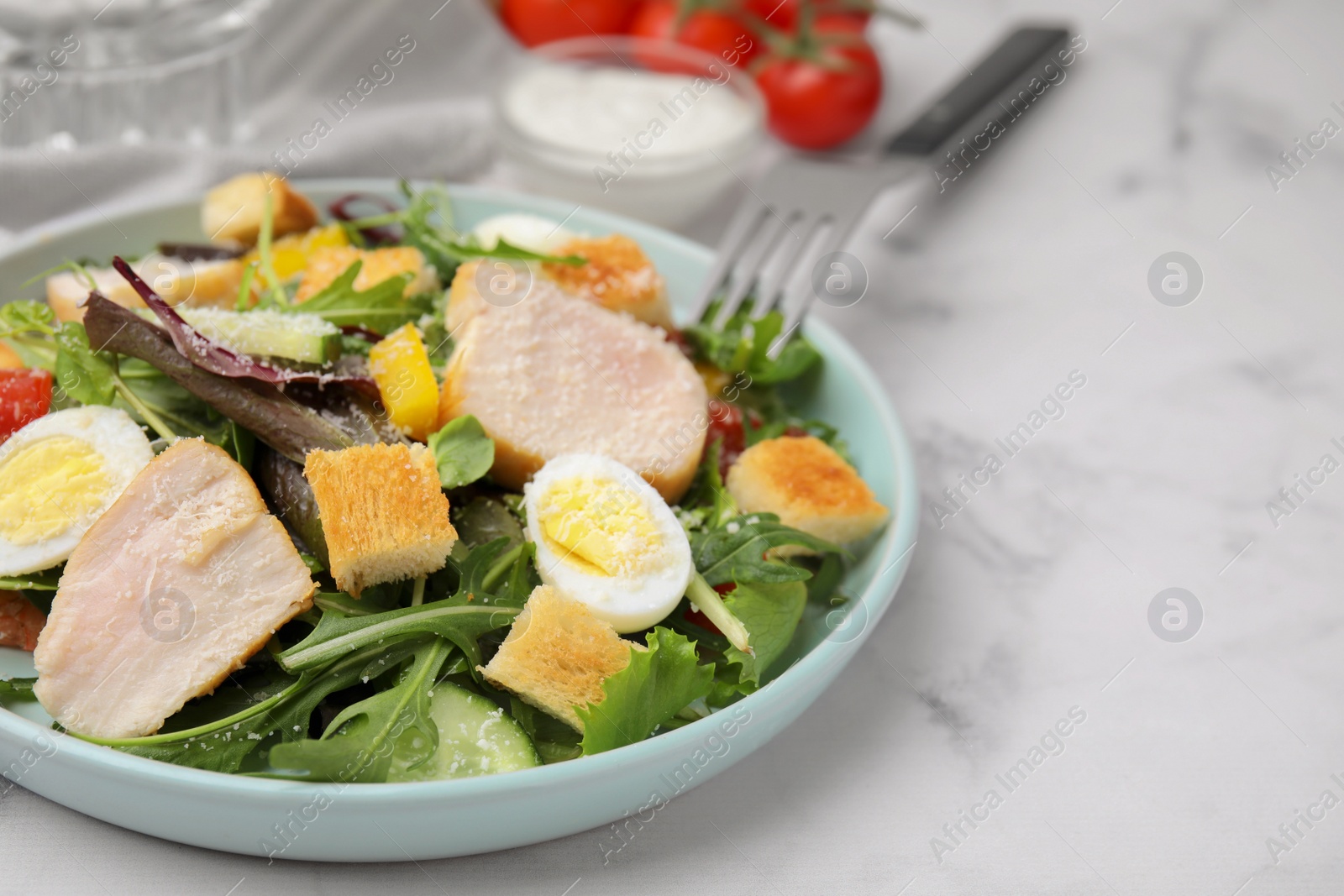 Photo of Delicious salad with croutons, chicken and eggs served on white marble table, closeup. Space for text