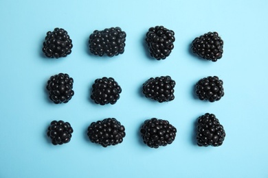 Flat lay composition with ripe blackberries on color background