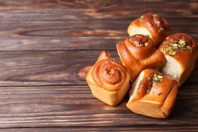 Tasty fresh pampushky. Traditional Ukrainian buns with garlic on wooden table, space for text