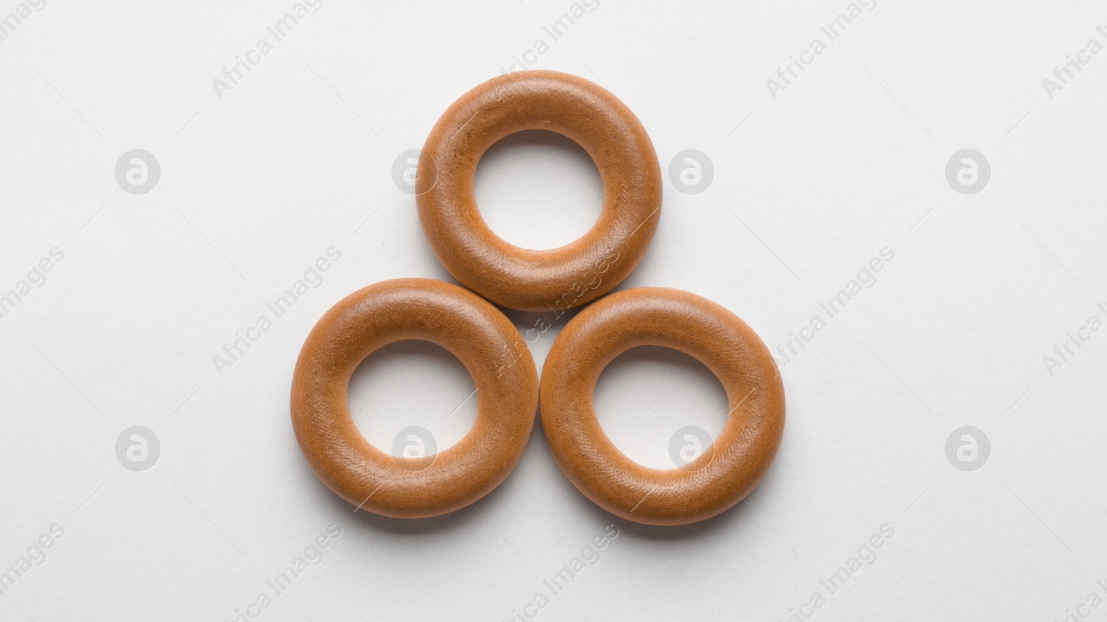 Photo of Tasty dry bagels (sushki) on light background, flat lay