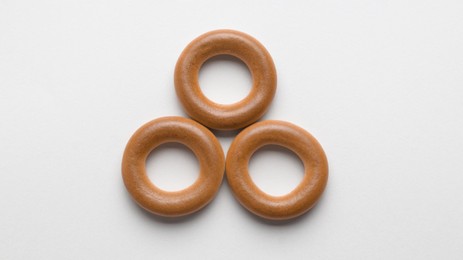 Tasty dry bagels (sushki) on light background, flat lay